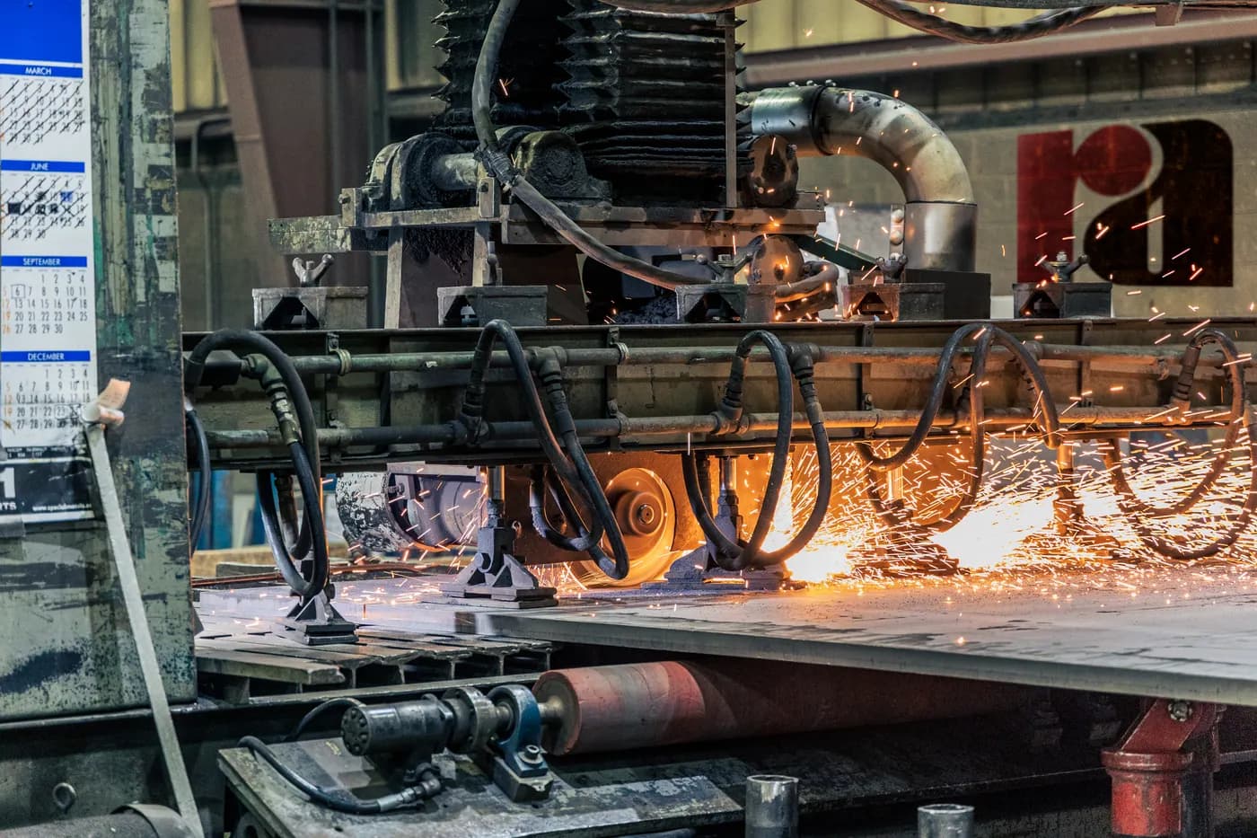 Industrial machinery cutting metal on a factory floor